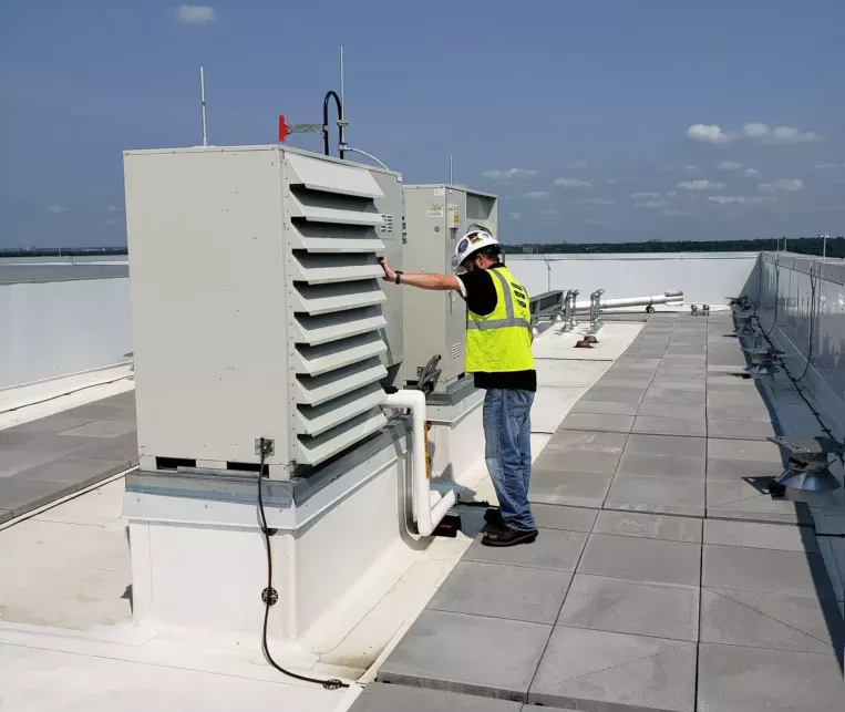 Man checking HVAC boxes on the roof